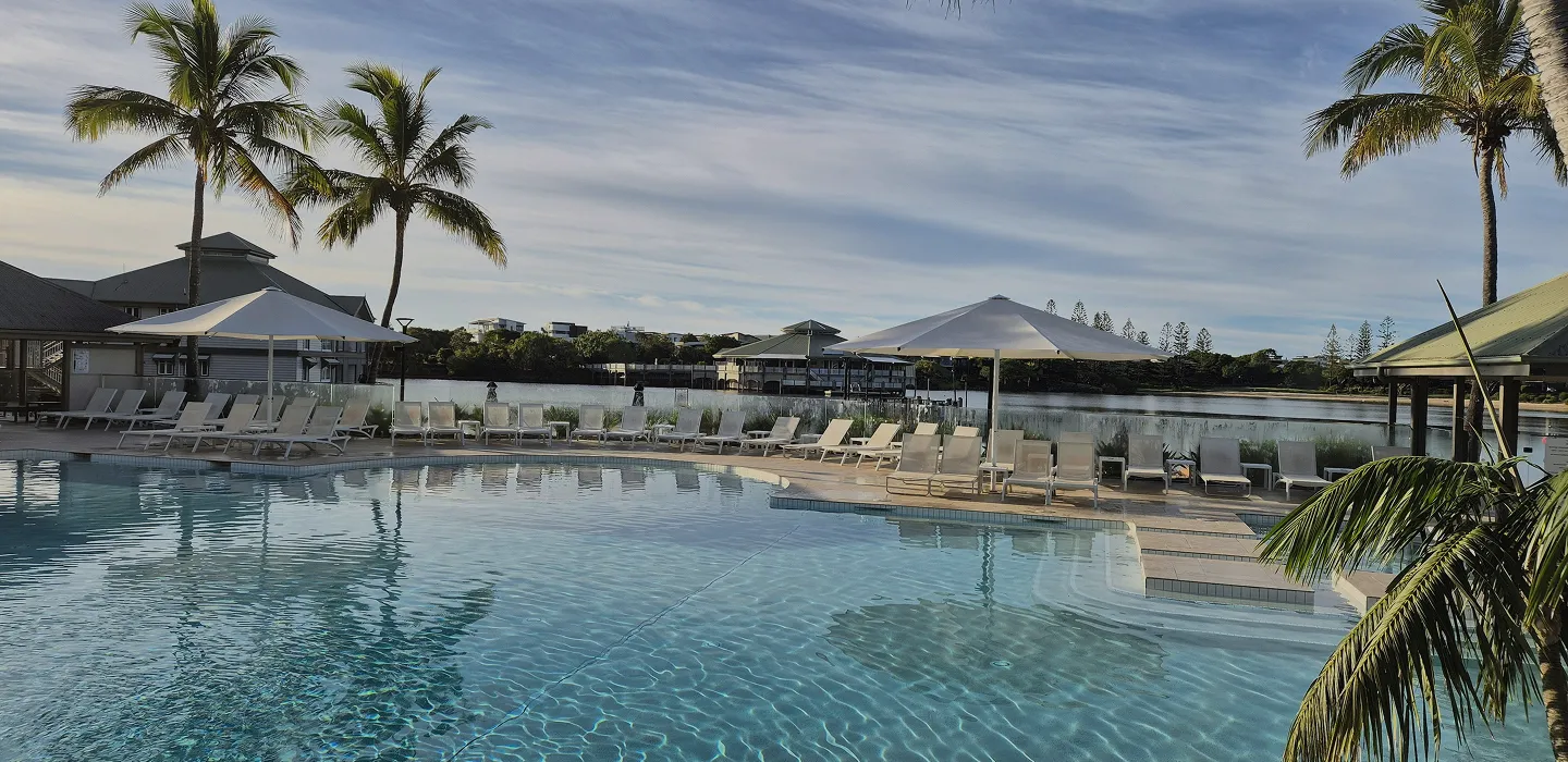 A tropical resort pool surrounded by palm trees